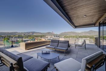 A patio with a table and chairs overlooking a mountain range.